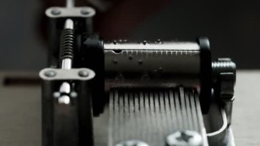 Müzik kutusu mekanizması beyaz arka planda yakın çekim yapar. İş sırasında müzik kutusunun içinde. solucan dişlisi.