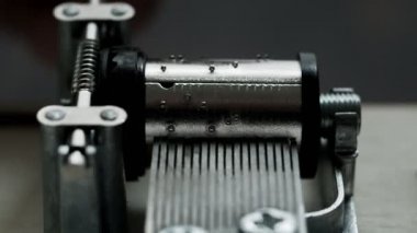 Müzik kutusu mekanizması beyaz arka planda yakın çekim yapar. İş sırasında müzik kutusunun içinde. solucan dişlisi.