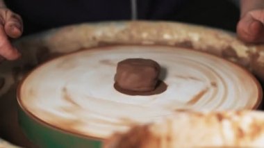 Eller çömlekçi çarkında çalışıyor. Potter çömlekçinin çarkındaki çömlek aletleriyle kil ürünü şekillendiriyor, el işi fabrikası özgün. Kapatın. 4k
