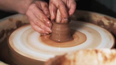 Eller çömlekçi çarkında çalışıyor. Potter çömlekçinin çarkındaki çömlek aletleriyle kil ürünü şekillendiriyor, el işi fabrikası özgün. Kapatın. 4k