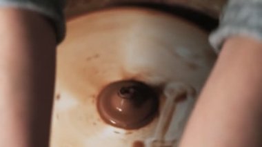 Eller çömlekçi çarkında çalışıyor. Potter çömlekçinin çarkındaki çömlek aletleriyle kil ürünü şekillendiriyor, el işi fabrikası özgün. Kapatın. 4k