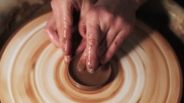 Eller çömlekçi çarkında çalışıyor. Potter çömlekçinin çarkındaki çömlek aletleriyle kil ürünü şekillendiriyor, el işi fabrikası özgün. Kapatın. 4k
