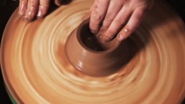 Eller çömlekçi çarkında çalışıyor. Potter çömlekçinin çarkındaki çömlek aletleriyle kil ürünü şekillendiriyor, el işi fabrikası özgün. Kapatın. 4k