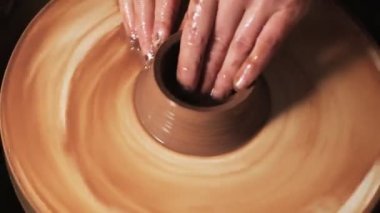 Eller çömlekçi çarkında çalışıyor. Potter çömlekçinin çarkındaki çömlek aletleriyle kil ürünü şekillendiriyor, el işi fabrikası özgün. Kapatın. 4k