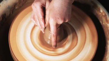 Eller çömlekçi çarkında çalışıyor. Potter çömlekçinin çarkındaki çömlek aletleriyle kil ürünü şekillendiriyor, el işi fabrikası özgün. Kapatın. 4k