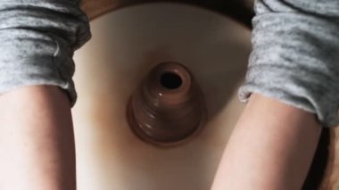 Eller çömlekçi çarkında çalışıyor. Potter çömlekçinin çarkındaki çömlek aletleriyle kil ürünü şekillendiriyor, el işi fabrikası özgün. Kapatın. 4k
