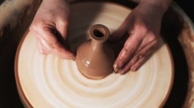 Eller çömlekçi çarkında çalışıyor. Potter çömlekçinin çarkındaki çömlek aletleriyle kil ürünü şekillendiriyor, el işi fabrikası özgün. Kapatın. 4k