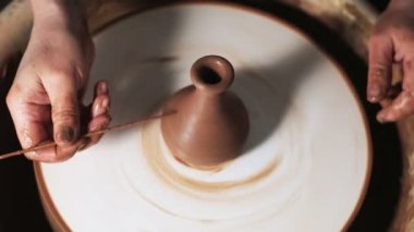 Eller çömlekçi çarkında çalışıyor. Potter çömlekçinin çarkındaki çömlek aletleriyle kil ürünü şekillendiriyor, el işi fabrikası özgün. Kapatın. 4k