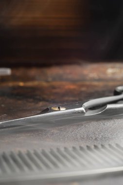 Paslı bir yüzey kuaför makası ve tarak üzerinde. Kapat. Rustik. Dikey oryantasyon. kopyalama alanı. buharlı araçlar