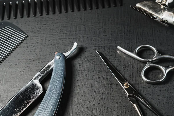 Klasik berber aletleri. Tehlikeli jilet, kuaför makası, eski manuel makas, tarak, tıraş fırçası. siyah monokrom. siyah arkaplan.