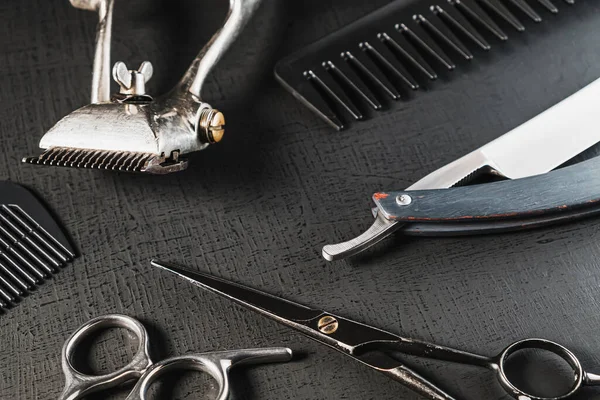 Klasik berber aletleri. Tehlikeli jilet, kuaför makası, eski manuel makas, tarak, tıraş fırçası. siyah monokrom. siyah arkaplan.