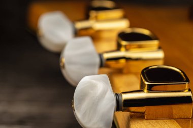 Tahtadaki eski akustik altın gitarın başı. Makro fotoğraf. Yatay yönelim