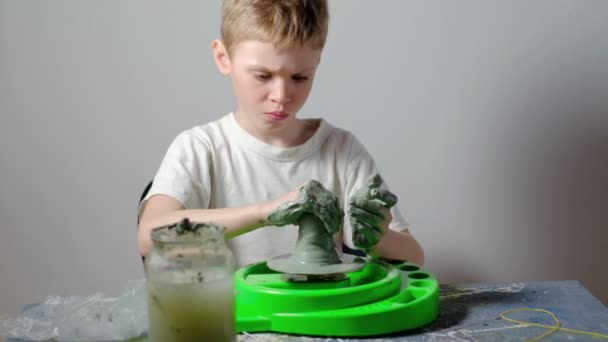 Ein Siebenjähriger Junge Der Mit Ton Verschmutzt Ist Konzentriert Sich — Stockvideo