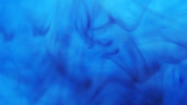 Siyah mürekkep yayılır ve mavi suyun altında kıvrılır. 4k