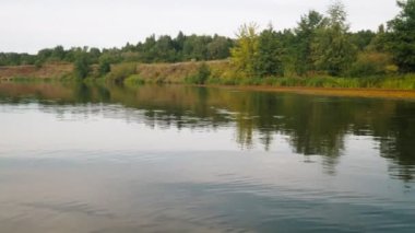 Yazın nehir. Sudaki ağaçların yansıması. Sudan gelen panorama. Yaz nehri manzarası. 4k