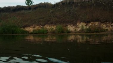Yazın nehir. Sudaki ağaçların yansıması. Sudan gelen panorama. Yaz nehri manzarası. 4k