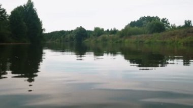 Yazın nehir. Sudaki ağaçların yansıması. Sudan gelen panorama. Yaz nehri manzarası. 4k