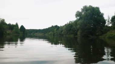 Yazın nehir. Sudaki ağaçların yansıması. Sudan gelen panorama. Yaz nehri manzarası.