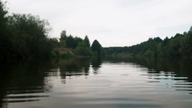 Yazın nehir. Sudaki ağaçların yansıması. Sudan gelen panorama. Yaz nehri manzarası.