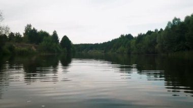 Yazın nehir. Sudaki ağaçların yansıması. Sudan gelen panorama. Yaz nehri manzarası.
