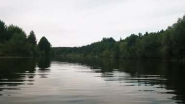 Yazın nehir. Sudaki ağaçların yansıması. Sudan gelen panorama. Yaz nehri manzarası.