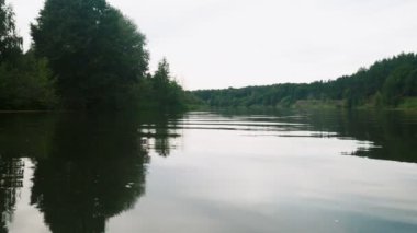 Yazın nehir. Sudaki ağaçların yansıması. Sudan gelen panorama. Yaz nehri manzarası.