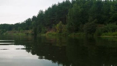 Yazın nehir. Sudaki ağaçların yansıması. Sudan gelen panorama. Yaz nehri manzarası.
