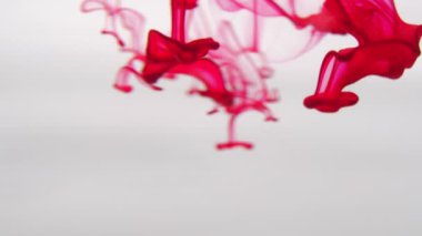 Kırmızı boya mürekkebi yavaş çekimde fotokopi alanı ile suya düşer. Su altında dönen mürekkepli bulut. 4k