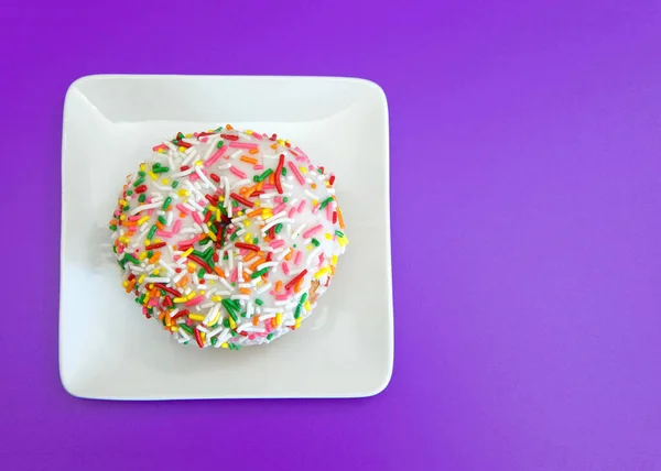 보이는 바닐라 케이크 도넛과 색깔의 렛으로 보라색 배경에 사각형 흰색자기 — 스톡 사진