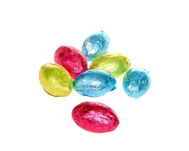 Parlak renkli folyo ambalajlarıyla kaplanmış çikolatalı paskalya yumurtaları beyaz üzerine izole edilmiş.