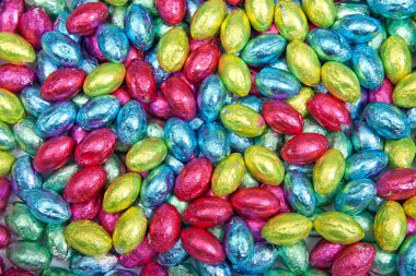 Parlak renkli folyolarla kaplanmış Paskalya yumurtalarının arka planını kapat.