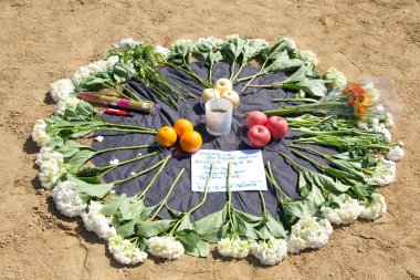 San Francisco, CA - Mar 21, 2021: Alter of flowers, fruit and incense at the Sit, Walk, Listen rally. Honoring the lives of women lost in the Atlanta spree killing. Names of women killed on paper. clipart