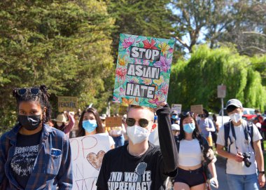 Berkeley, CA - 28 Mart 2021: Asya Pasifik Adalı Gençlik Yükselişi Yürüyüşü 'nün kimliği belirsiz katılımcıları Aquatic Park' tan yaya geçidine yürüyorlar. Asya Karşıtı Nefret Toplantısı.