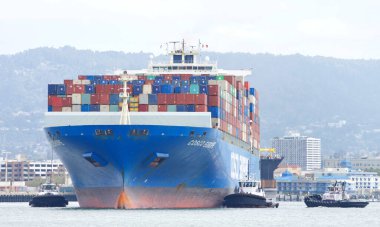 Oakland, CA - Apr 3, 2021: Multiple tugboats work in tandem to assist cargo ship COSCO EUROPE to turn prior to docking at the Port of Oakland.