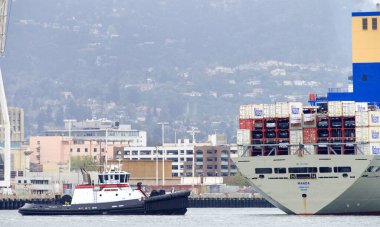 Oakland, CA - Apr 5, 2021: Tugboat JAMIE RENEA at the stern of Matson Cargo Ship MANOA, assisting the vessel to maneuver into the Port of Oakland.
