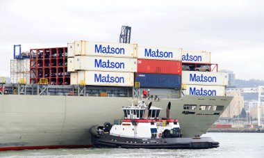 Oakland, CA - Apr 5, 2021: Tugboat JAMIE RENEA assisting Matson Cargo Ship MANOA to maneuver into the Port of Oakland.