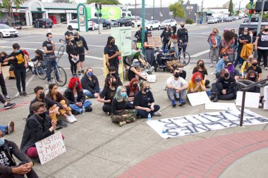 Alameda, CA - 24 Nisan 2021: Kimliği belirsiz katılımcılar Alameda Polis Karakolu önünde düzenlenen gençlik lideri Polis Vahşiliği Yürüyüşü 'nde konuşmacıları dinliyorlar