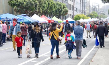 San Francisco, CA - 29 Mayıs 2021: Mission Distric 'teki Karnaval Festivali' nin kimliği belirsiz katılımcıları, ana caddede mallarını satan satıcılarla birlikte yürüyorlar..