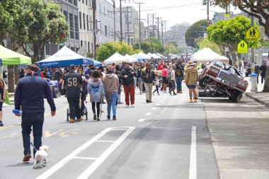 San Francisco, CA - 29 Mayıs 2021: Mission Distric 'teki Karnaval Festivali' nin kimliği belirsiz katılımcıları, ana caddede mallarını satan satıcılarla birlikte yürüyorlar..
