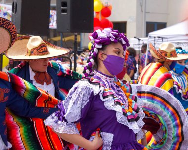 San Francisco, CA - 29 Mayıs 2021: Mission District Karnaval Festivali 'ne kimliği belirsiz katılımcılar. Latin dansçılar ana sahnede kültürel danslar yapıyorlar..