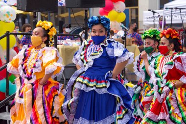 San Francisco, CA - 29 Mayıs 2021: Mission District Karnaval Festivali 'ne kimliği belirsiz katılımcılar. Latin dansçılar ana sahnede kültürel danslar yapıyorlar..