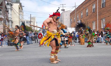 San Francisco, CA - 29 Mayıs 2021: Mission District Karnaval Festivali 'ne kimliği belirsiz katılımcılar. Aztek dansçıları bir sokak köşesinde gösteri yapıyorlar..