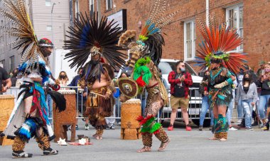 San Francisco, CA - 29 Mayıs 2021: Mission District Karnaval Festivali 'ne kimliği belirsiz katılımcılar. Aztek dansçıları bir sokak köşesinde gösteri yapıyorlar..