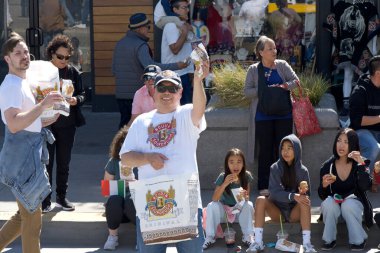 San Francisco, CA - 12 Ekim 2025: 39. İskelede başlayan İtalyan Mirası Geçidi 'ne katılanlar. Boudin Pastanesi çalışanları ekşi ekmek örnekleri dağıtıyor..