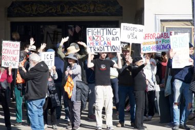 Oakland, CA - 11 Ocak 2026: Oakland 'daki Grand Theater' ın yanında düzenlenen iyi protesto gösterisinde kimliği belirsiz katılımcılar