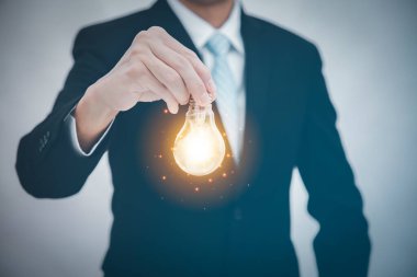 İş adamı, ampulü grafik ekranı, Teknoloji İşlem Sistemi İş Konseptinin Ekran Simgesi 'nde tutuyor.