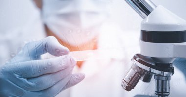 Koronavirüs için mikroskopla çalışan biyokimya araştırmacısı, bilim, kimya, biyoloji, tıp ve insan kavramı için kimyasal sıvı içeren laboratuvar camları. 