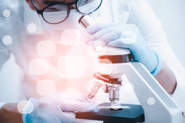 Koronavirüs için mikroskopla çalışan biyokimya araştırmacısı, bilim, kimya, biyoloji, tıp ve insan kavramı için kimyasal sıvı içeren laboratuvar camları. 