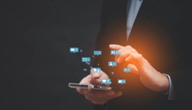 Sosyal medya ve pazarlama simgesi olan cep telefonu ve dizüstü bilgisayarı kullanan işadamı elleri, kişinin el ele tutuşması cihazı, İnternet dijital pazarlaması, teknoloji interneti ve sosyal medya ağı  