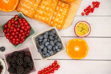 Kahvaltıda tereyağlı ekmek ve mısır gevreğiyle fincanda süt, çilek, yabanmersini, ahududu, kivi ve taze portakal ile servis edilir..